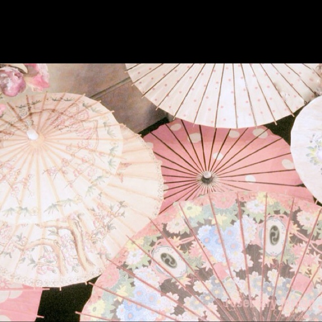 several pink and white parasols sitting next to each other