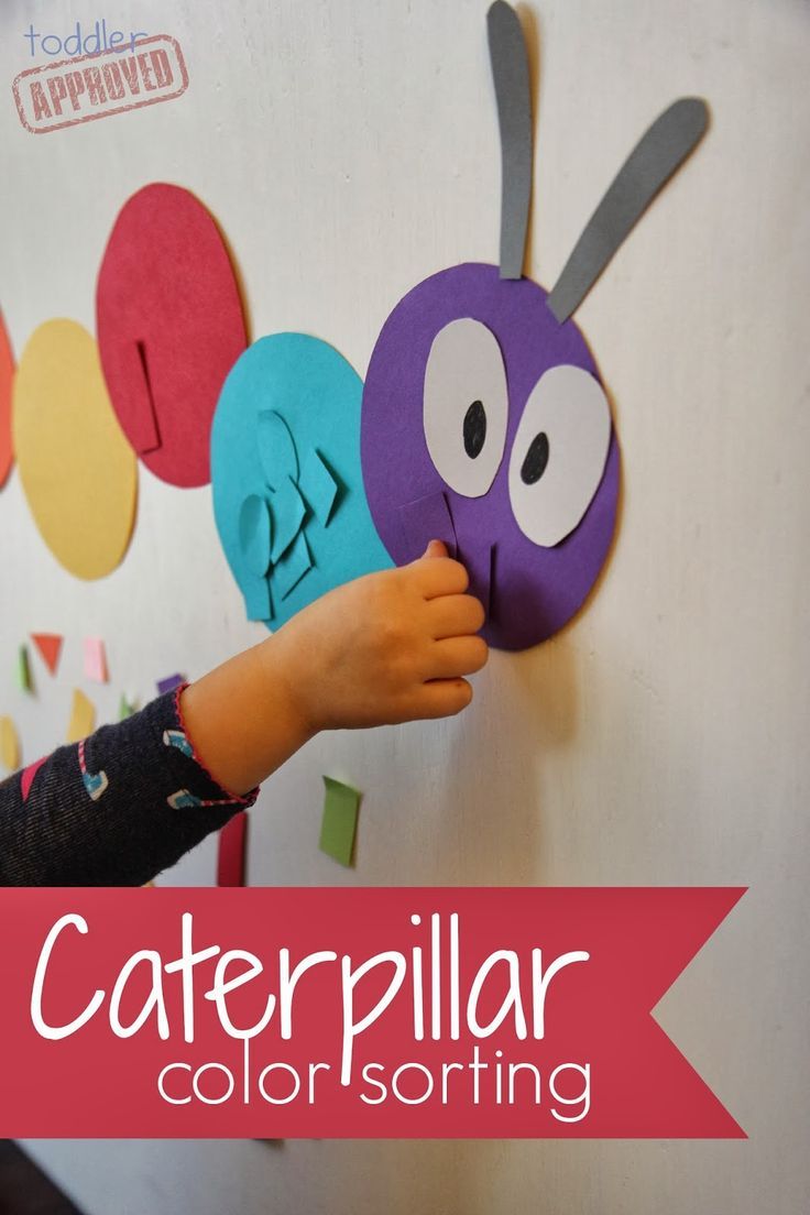 a child's hand is touching the caterpillar wall decoration