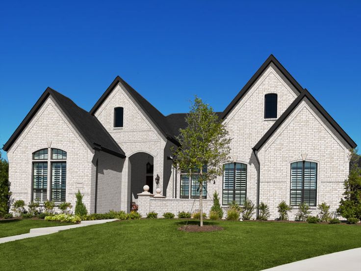 a large brick house sitting on top of a lush green field