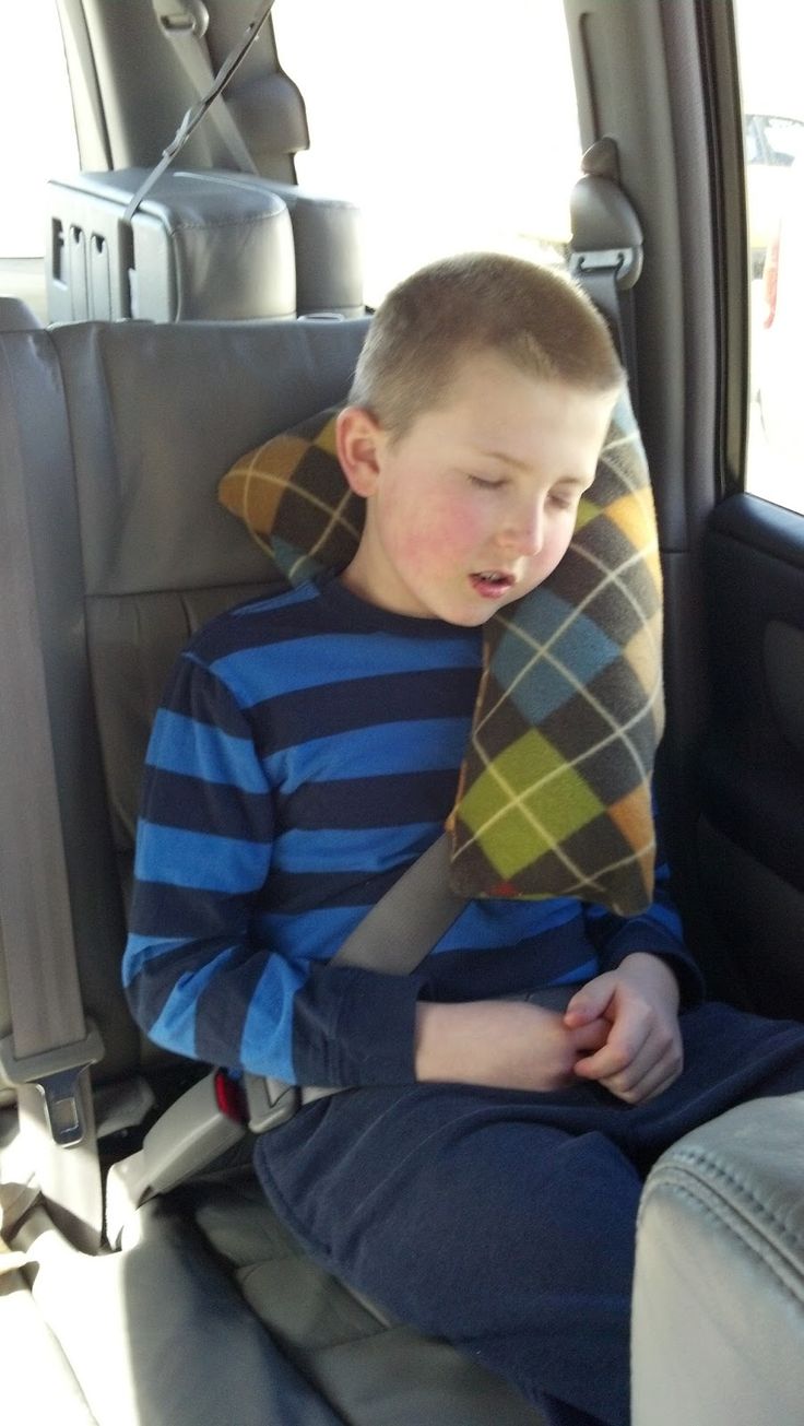 a young boy sitting in the back seat of a car