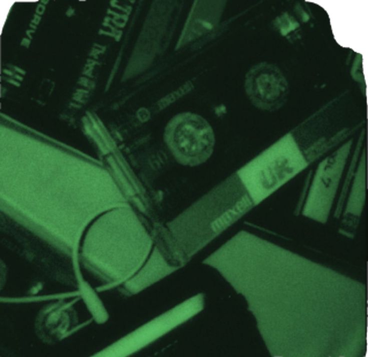 a pile of cassettes sitting next to each other on top of a table under a green light