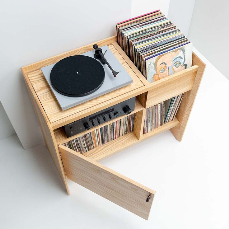 a record player is sitting on top of a shelf filled with cds and vinyl records