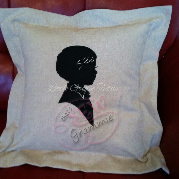 a pillow with a silhouette of a boy on it sitting on a red leather chair