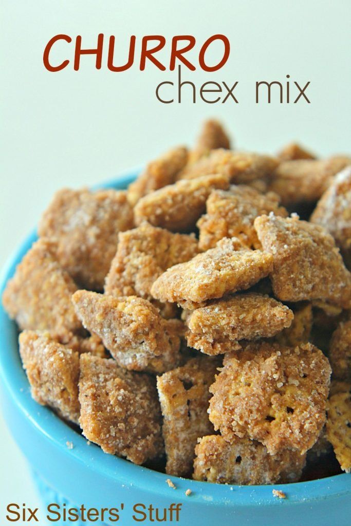 a blue bowl filled with chex mix sitting on top of a table