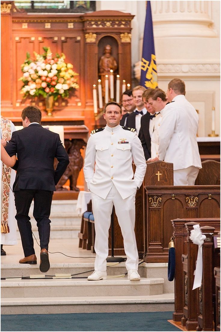 a man in a white suit is walking down the aisle