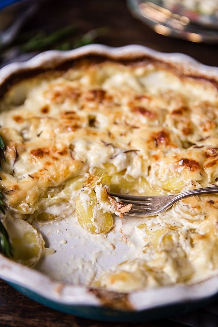 a close up of a casserole dish on a table with a fork in it