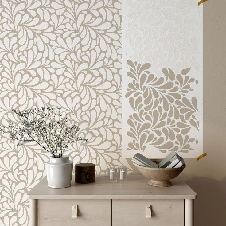 a table with two vases on top of it next to a wallpaper design