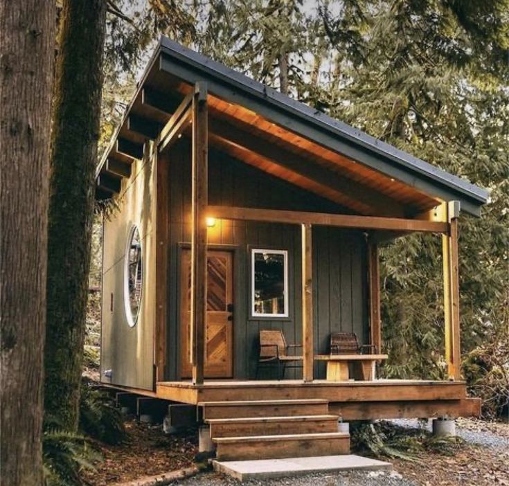 a small cabin in the woods with steps leading up to it's door and porch