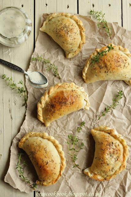 four small pastries sitting on top of a piece of paper next to a spoon