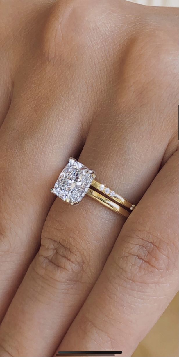 a woman's hand with two rings on it and the ring has an oval shaped diamond