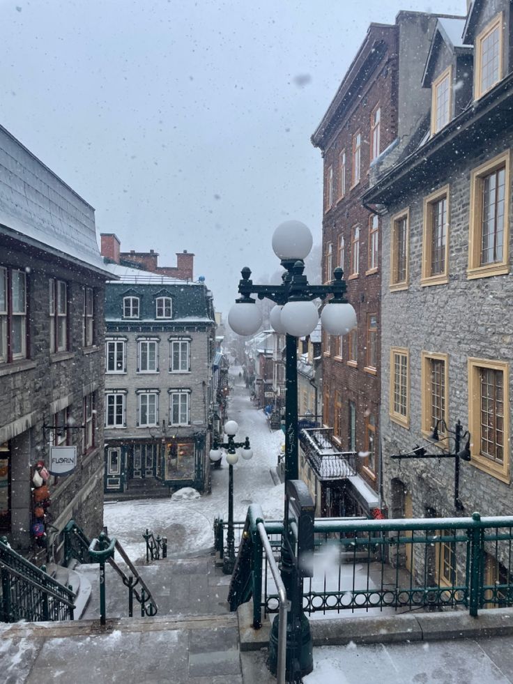 a snowy street scene with buildings and stairs