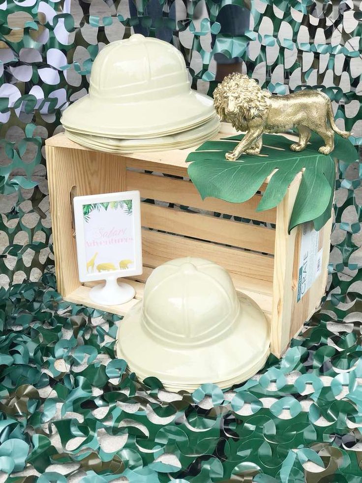 a wooden box filled with green leaves next to a white fireman's helmet