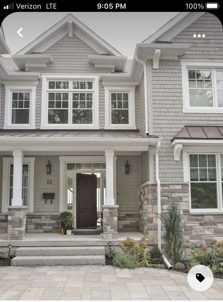 a large house with two story windows and stone steps leading up to the front door