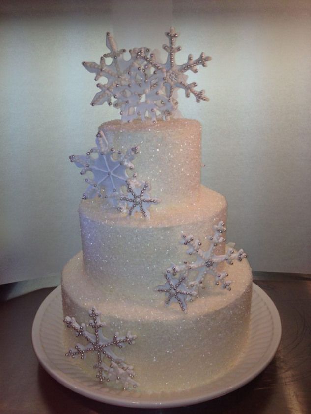 a three tiered cake with snowflakes on it