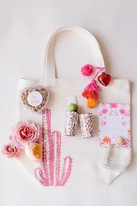 a white bag with pink flowers and other items on it