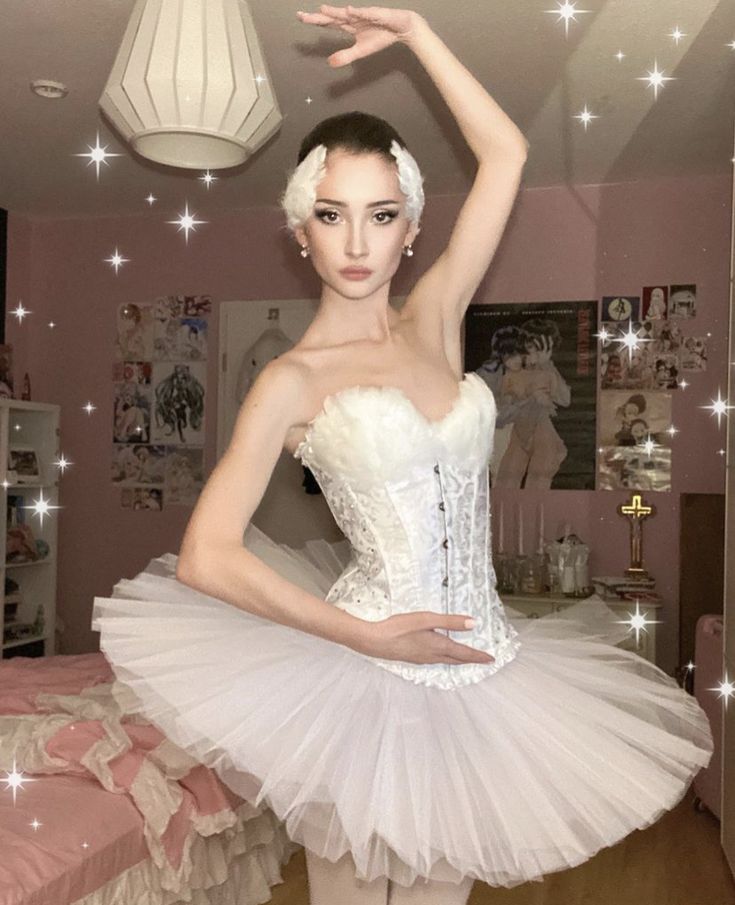 a woman in a white tutu is posing for the camera with her hand up