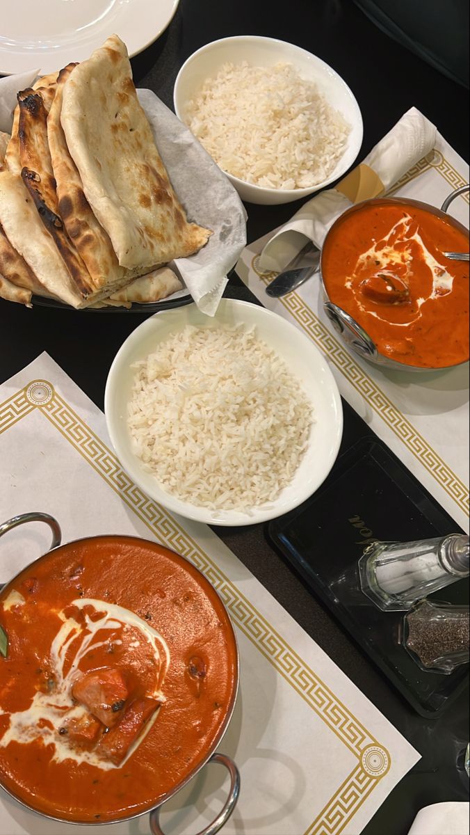 several plates of food on a table with utensils and napkins next to them