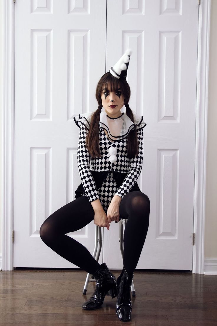 a woman sitting on top of a chair wearing a black and white checkered dress