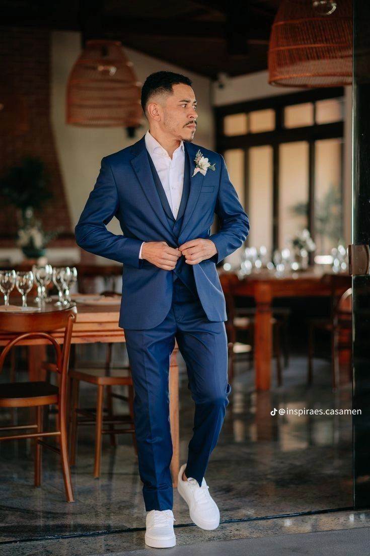 a man in a blue suit and white shoes