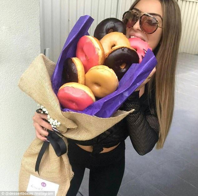 a woman holding a bag full of doughnuts