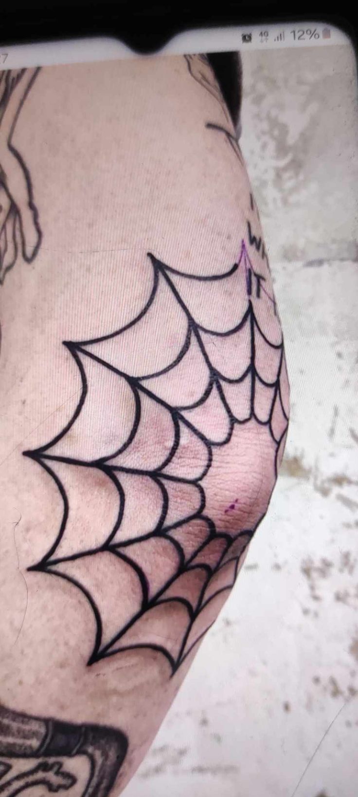 a man with a spider web tattoo on his leg