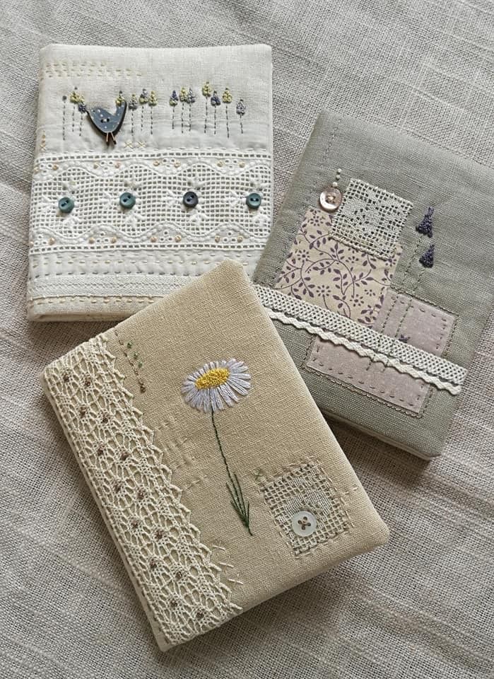 three embroidered napkins on a bed, one with a flower and the other with beads