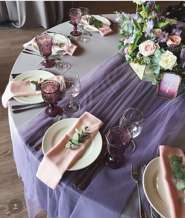 the table is set with plates and place settings