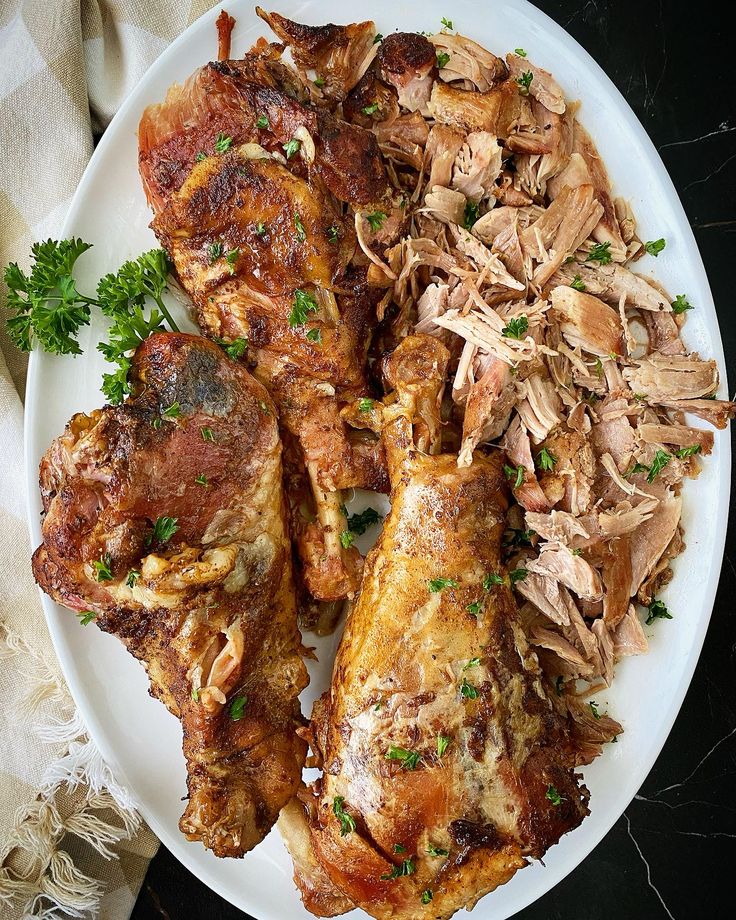 a white plate topped with meat and veggies on top of a black table