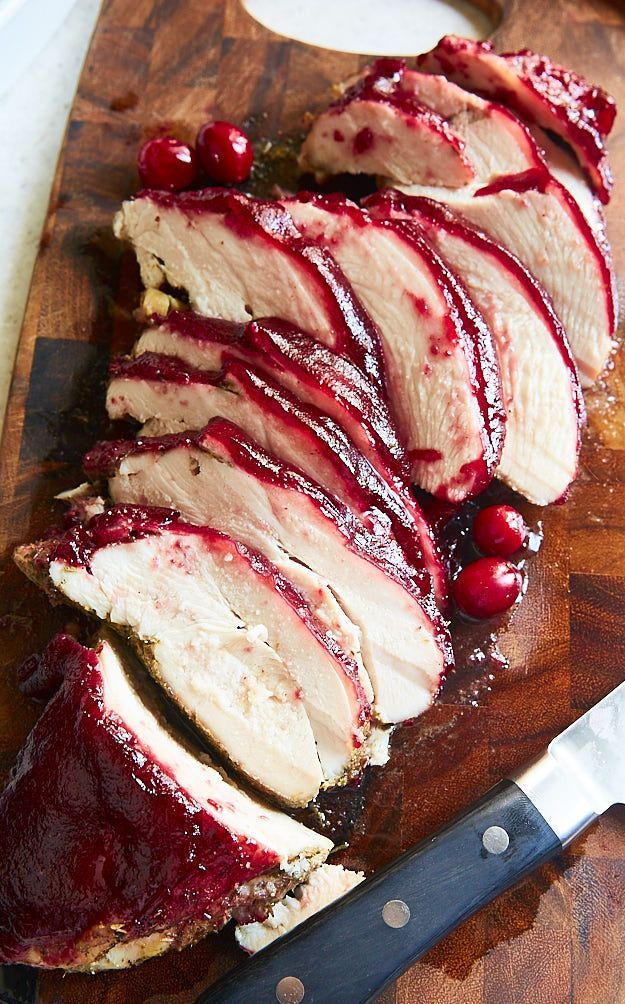 sliced up meat with cranberry sauce on a cutting board