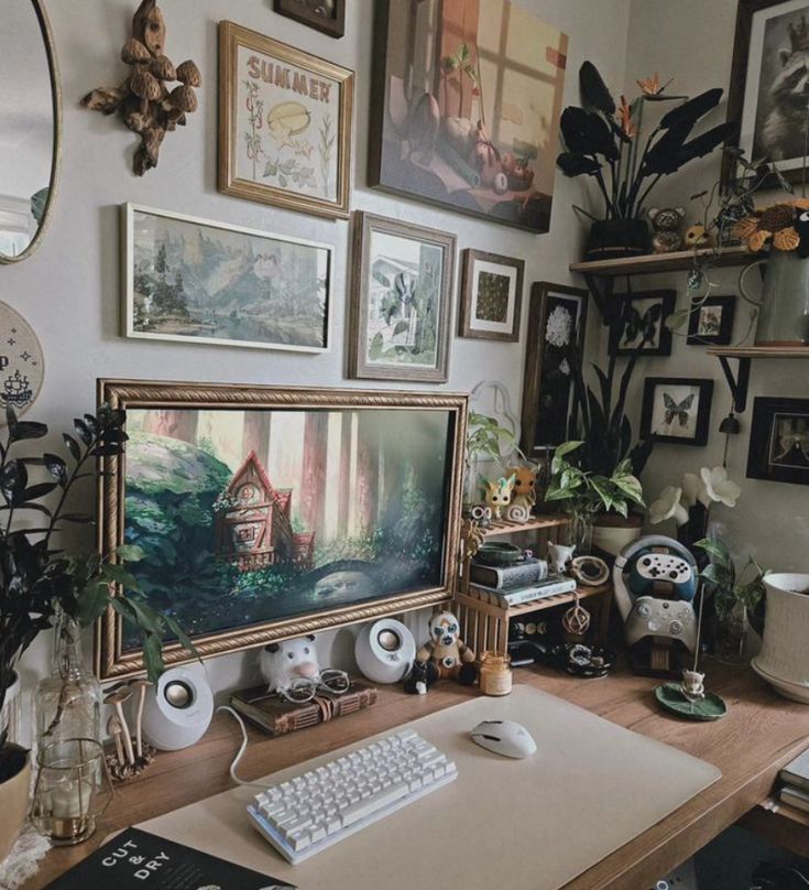 there is a computer on the desk with many pictures above it and plants in vases