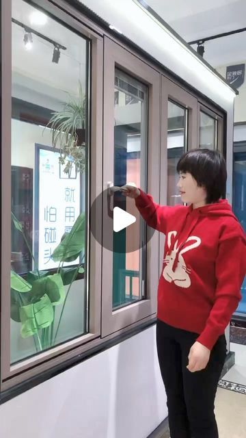 a woman standing in front of a window holding onto the side of a glass door