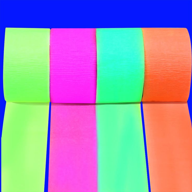 four rolls of neon colored tape on a blue background