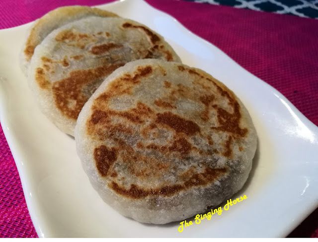 two pancakes on a white plate sitting on a table