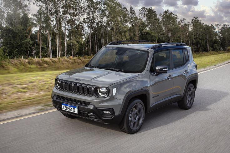 a grey jeep is driving down the road