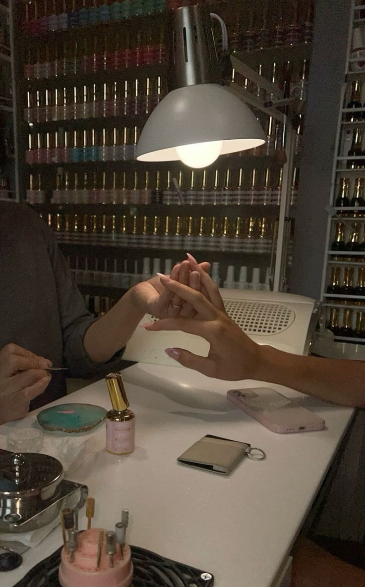 two people sitting at a table in front of a lamp and cake on the counter