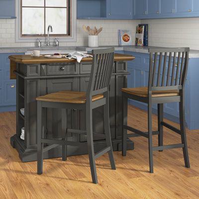 a kitchen with blue cabinets and an island in the middle, two chairs at the counter