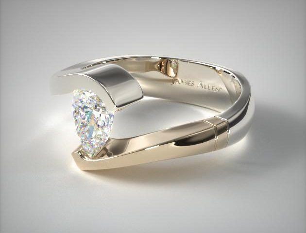 a ring with a single diamond in it on a white surface, the center stone is shaped like a heart