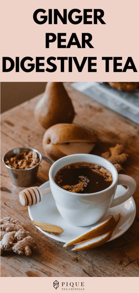 a cup of ginger pear digest tea sits on a saucer with spoons next to it