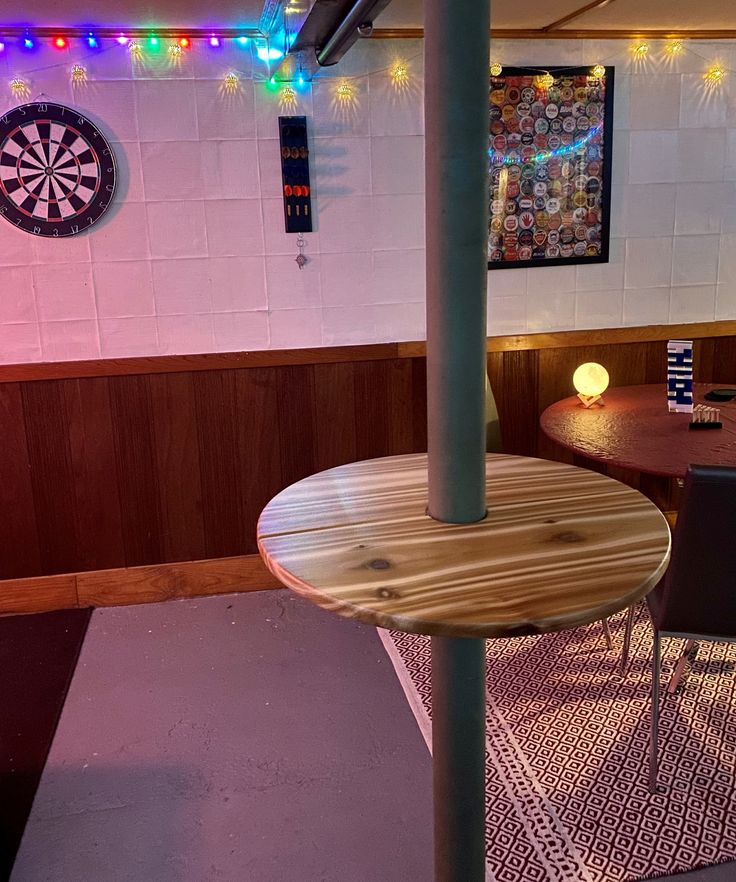 a room with tables and darts on the wall