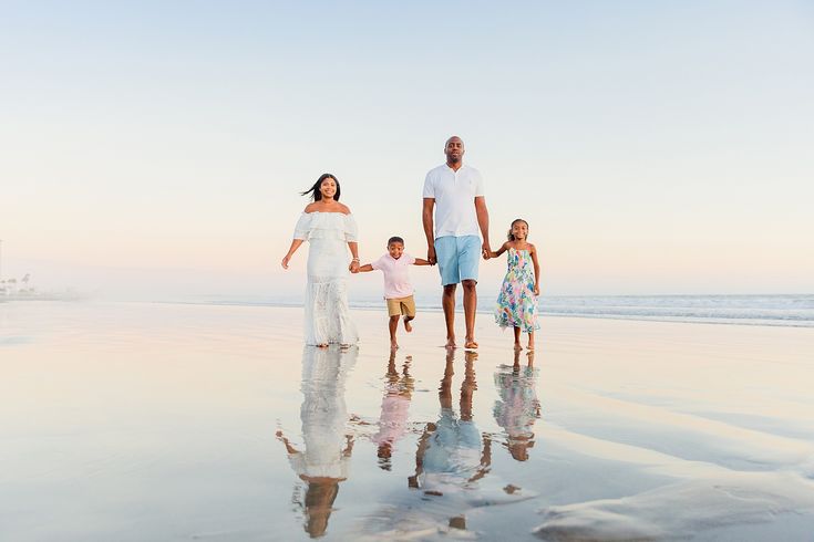 a family walking on the beach holding hands