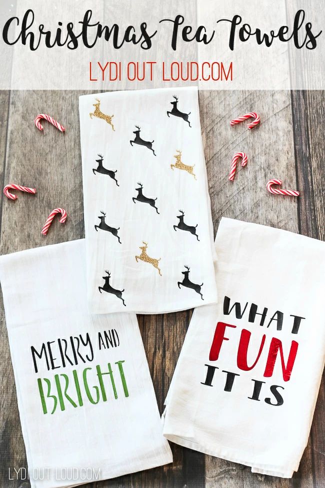 three christmas tea towels sitting on top of a wooden table next to candy canes