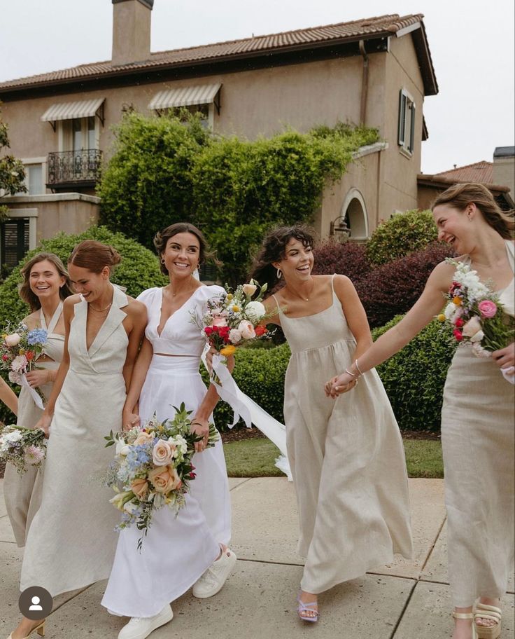 a group of women walking down a sidewalk holding bouquets