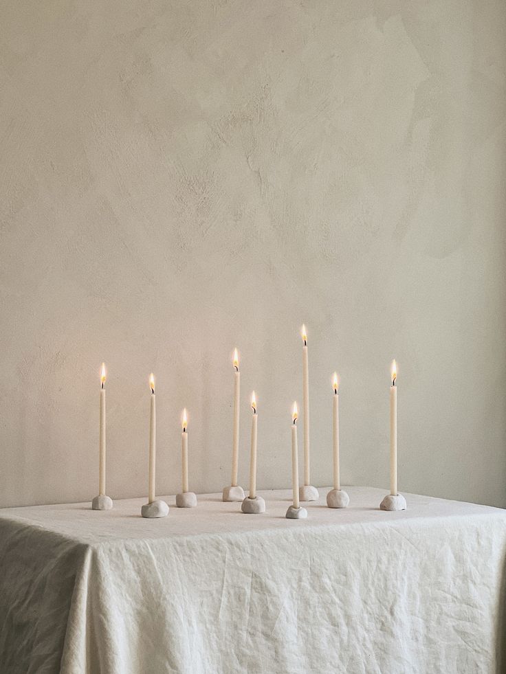 a table topped with lots of white candles