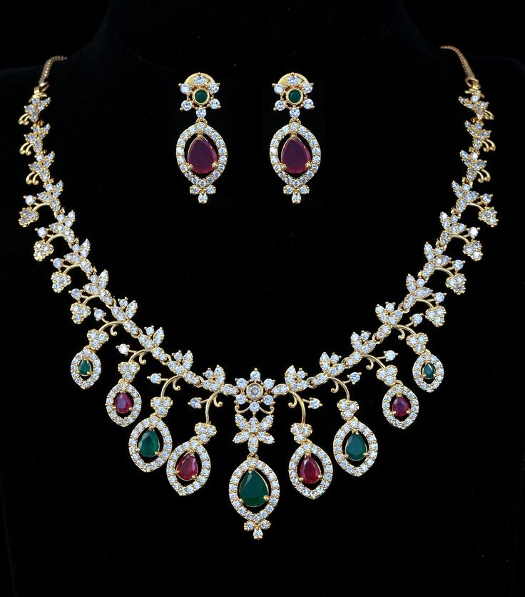 This exquisite Mothers Day Gift necklace showcases a charming South Indian-style gold floral design, featuring ruby and emerald stones. Intricately handcrafted, this statement jewelry will add a beautiful touch to wedding or special occasion outfit. Ruby Emerald Necklace, Indian Wedding Jewelry Sets, Occasion Outfit, Wedding Jewelry Set, Statement Choker, Ruby Emerald, Indian Wedding Jewelry, Emerald Necklace, Fancy Jewelry