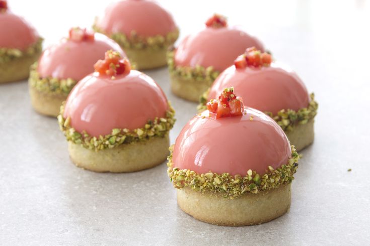 small desserts with pink icing and sprinkles on them