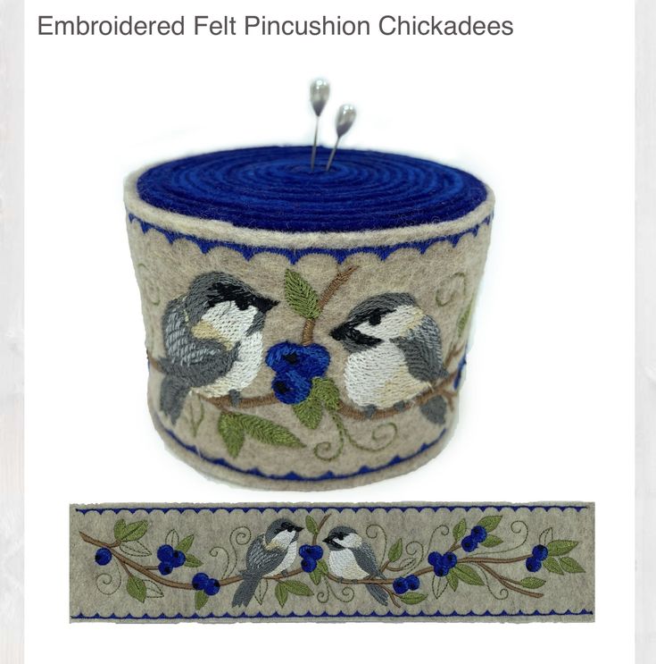 an embroidered felt pincustion chickades with blue flowers and leaves on it