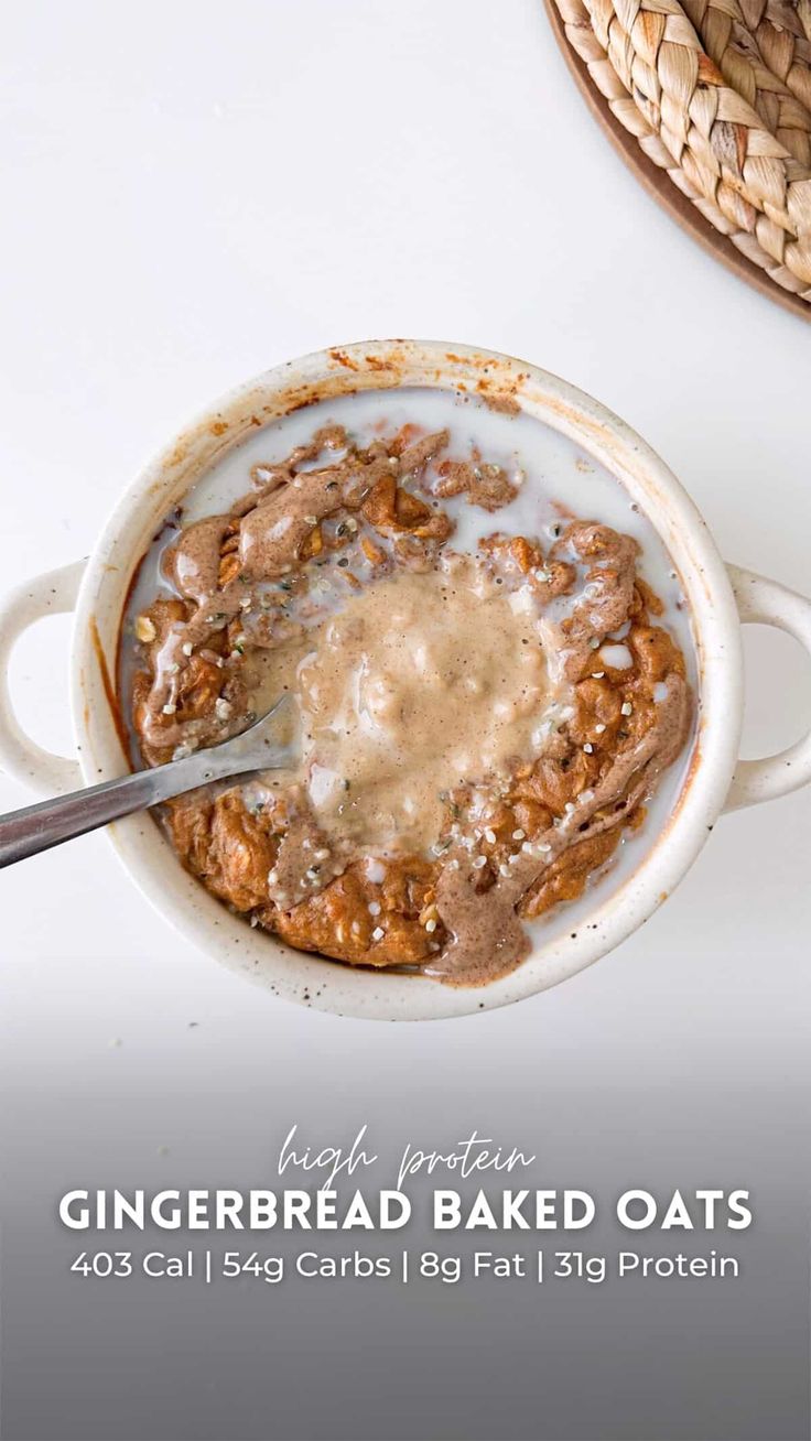 a white bowl filled with baked oats next to a straw hat on top of a table