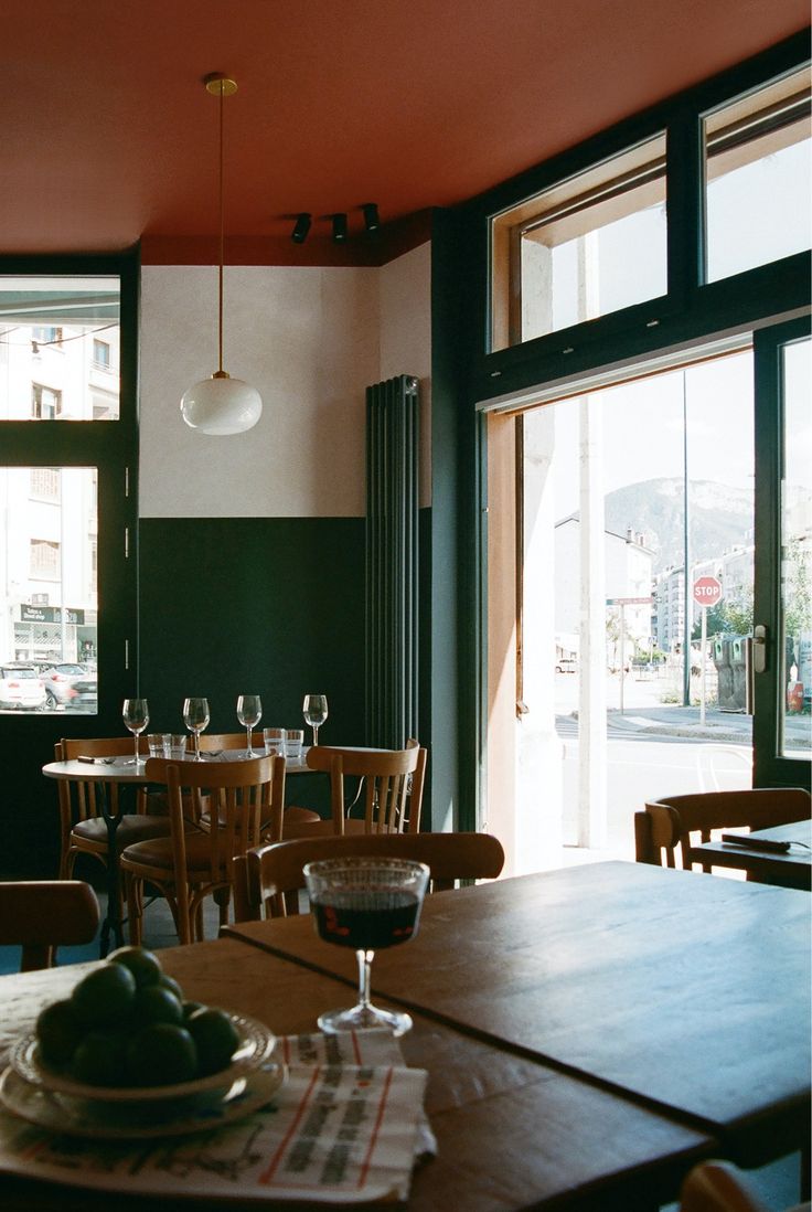 an empty restaurant with tables and chairs in front of large windows that look out onto the street