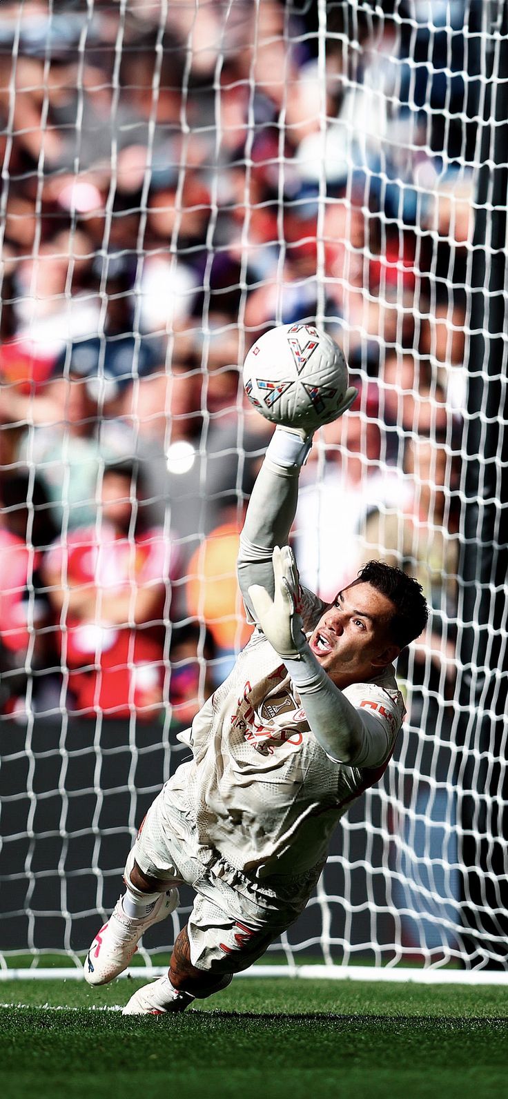 a soccer player is diving to catch the ball