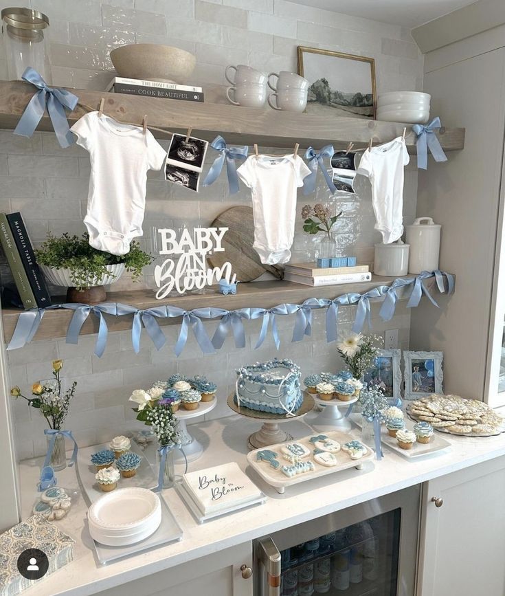 a baby shower party with blue and white items on shelves, including onesuits